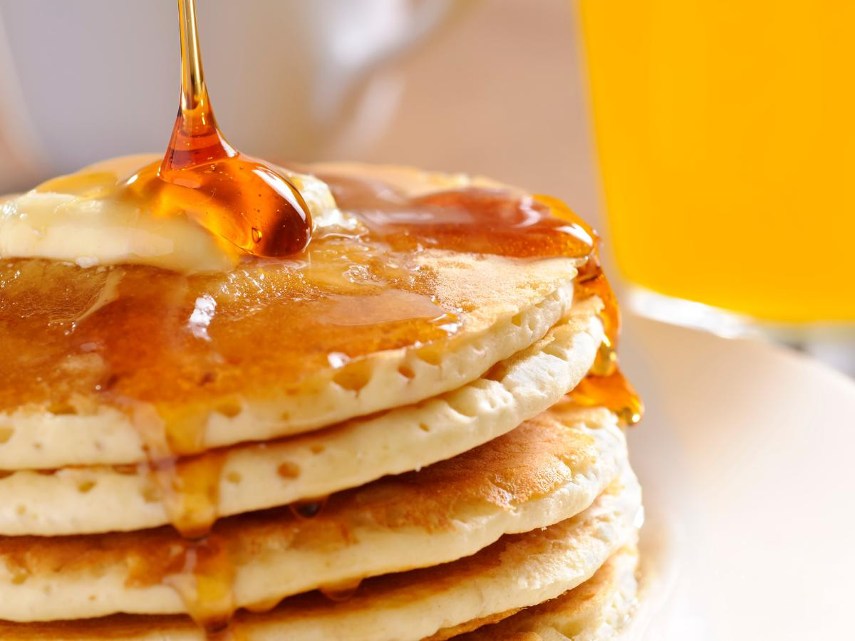 melted button and syrup on stack of pancakes