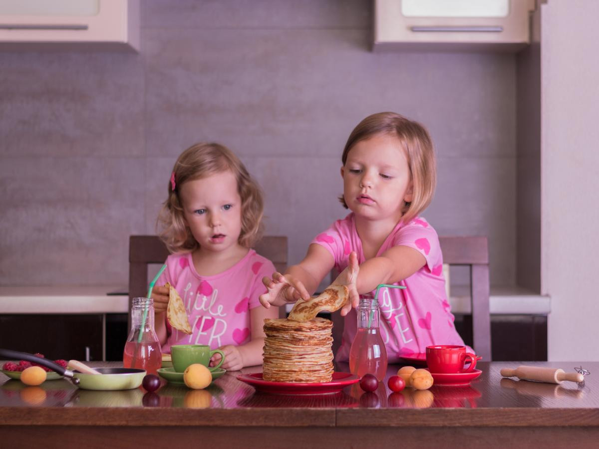 2 young girls eating pancakes